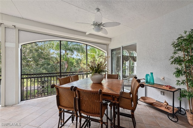 dining room with a textured ceiling, light tile patterned floors, and ceiling fan