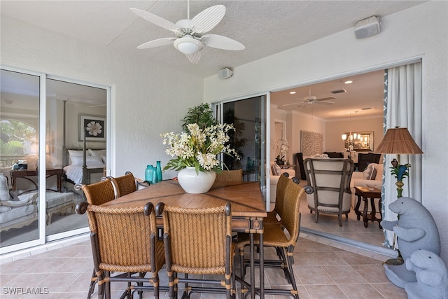 dining area featuring a textured ceiling, ceiling fan with notable chandelier, and light tile patterned floors