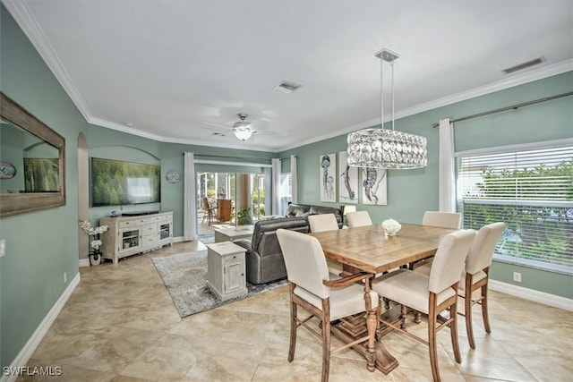 tiled dining area with crown molding and ceiling fan with notable chandelier