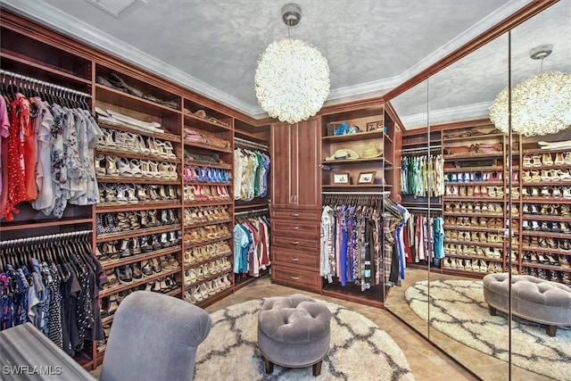 spacious closet featuring a chandelier