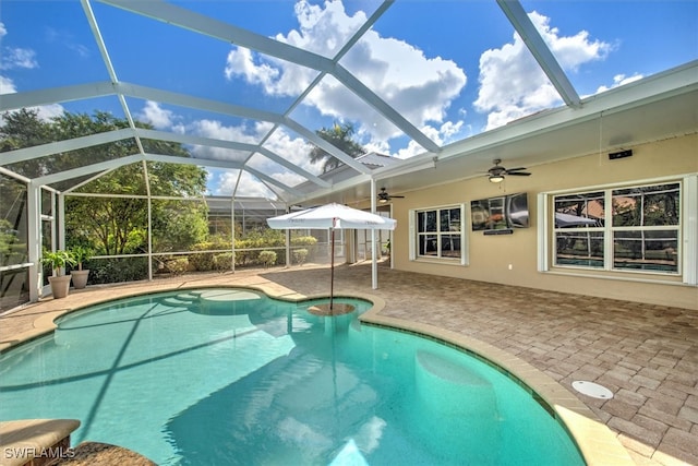 view of swimming pool with a lanai, ceiling fan, and a patio