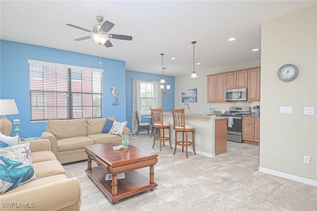 living room featuring ceiling fan with notable chandelier