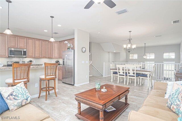 living room featuring ceiling fan with notable chandelier