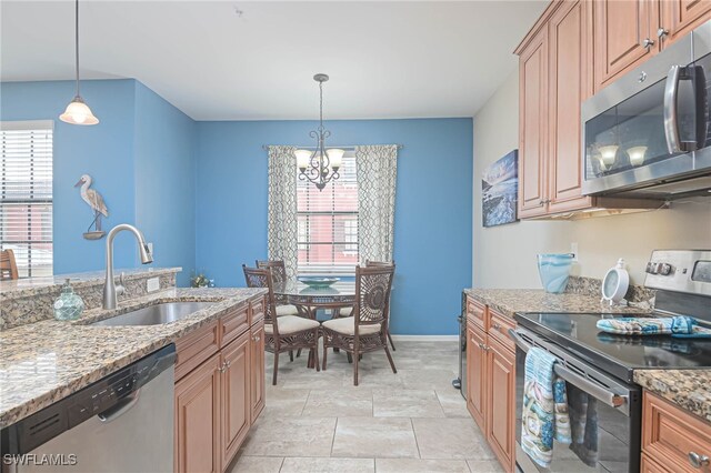 kitchen featuring plenty of natural light, stainless steel appliances, an inviting chandelier, and sink