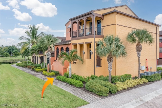 view of property exterior with a balcony and a yard