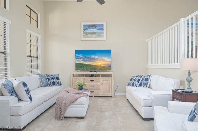 living room featuring ceiling fan and a towering ceiling