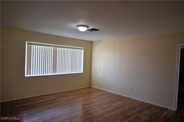 unfurnished room with dark wood-type flooring