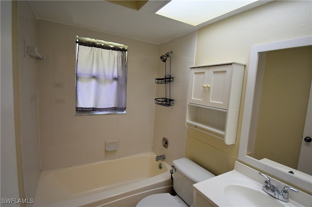 full bathroom featuring tiled shower / bath, vanity, and toilet