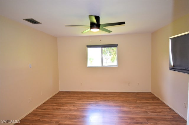 empty room with dark wood-type flooring and ceiling fan