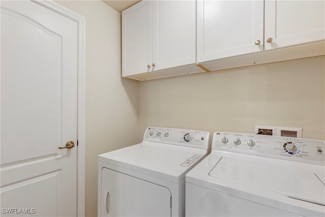 washroom featuring cabinets and washing machine and dryer