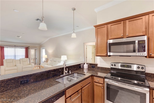 kitchen with dark stone counters, stainless steel appliances, vaulted ceiling, sink, and pendant lighting