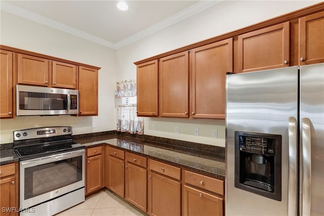 kitchen featuring light tile patterned flooring, crown molding, stainless steel appliances, and dark stone counters