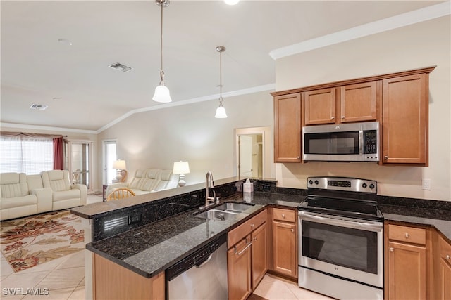 kitchen with appliances with stainless steel finishes, dark stone counters, pendant lighting, and sink