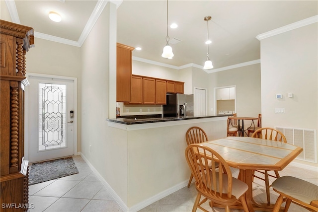 kitchen featuring decorative light fixtures, stainless steel fridge, ornamental molding, and kitchen peninsula