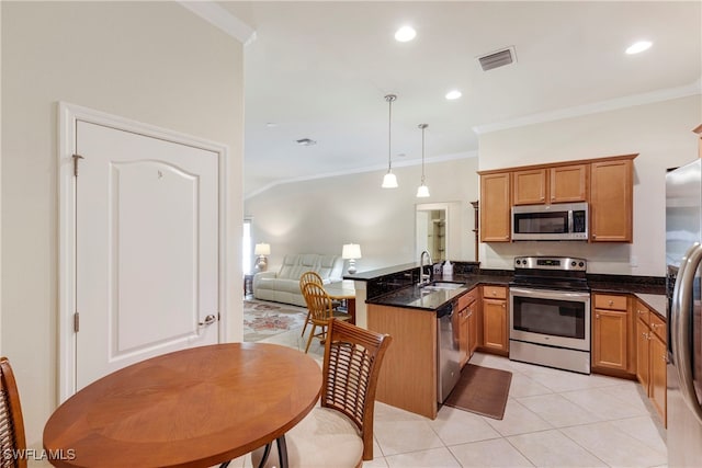 kitchen with sink, ornamental molding, decorative light fixtures, kitchen peninsula, and stainless steel appliances