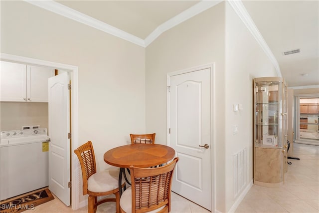 tiled dining space featuring washer / clothes dryer and crown molding