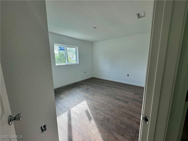 spare room featuring dark wood-type flooring