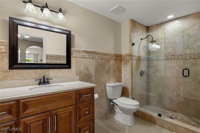 bathroom with vanity, an enclosed shower, tile walls, toilet, and tile patterned floors