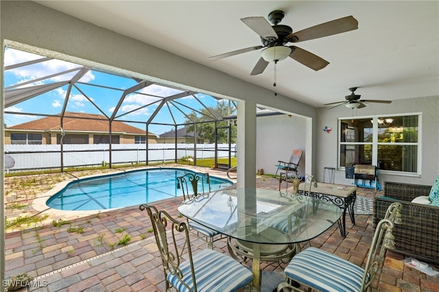 view of swimming pool with a lanai, ceiling fan, and a patio