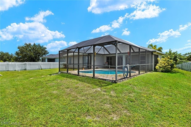 view of swimming pool featuring glass enclosure and a yard