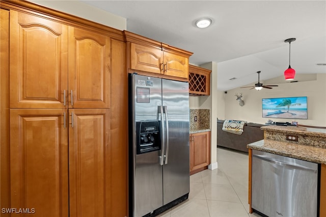 kitchen featuring light tile patterned floors, stone counters, vaulted ceiling, stainless steel appliances, and ceiling fan