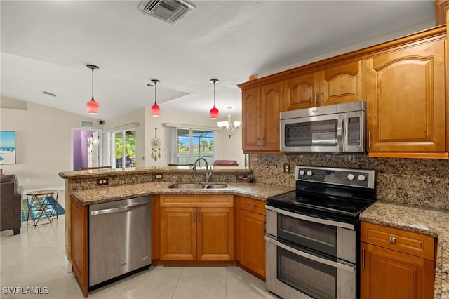 kitchen featuring a notable chandelier, hanging light fixtures, stainless steel appliances, sink, and lofted ceiling