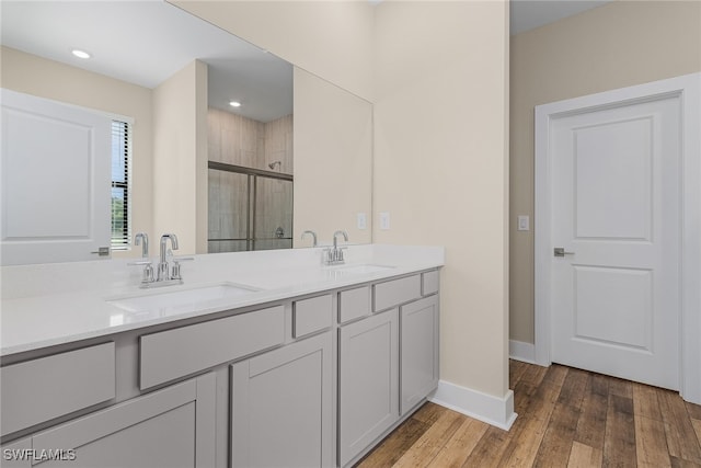 bathroom featuring wood-type flooring, vanity, and walk in shower