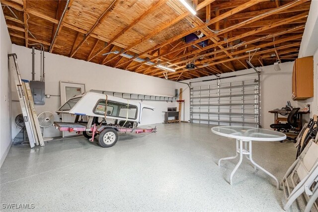 garage with electric panel and a garage door opener