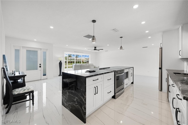 kitchen featuring appliances with stainless steel finishes, ceiling fan, pendant lighting, white cabinets, and a center island