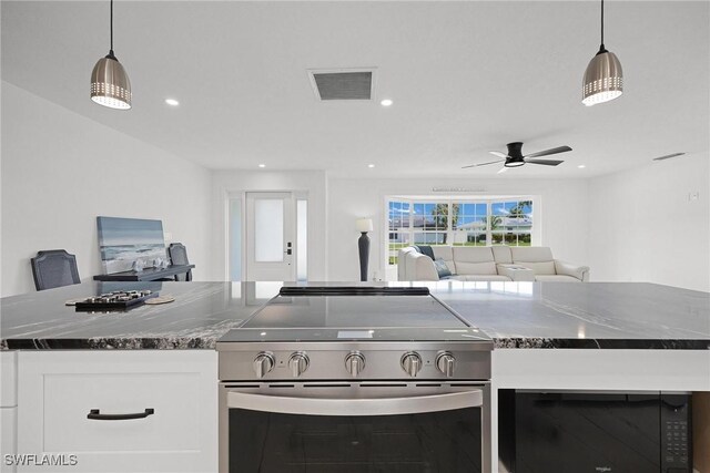 kitchen with white cabinets, ceiling fan, high end range, and hanging light fixtures