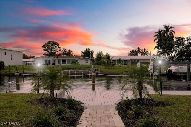 view of home's community with a water view and a dock