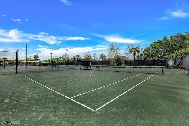 view of tennis court featuring fence