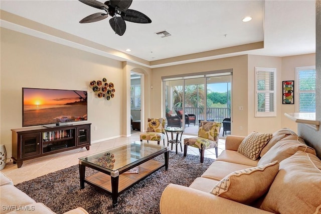 living room with ceiling fan, tile patterned flooring, recessed lighting, visible vents, and a tray ceiling