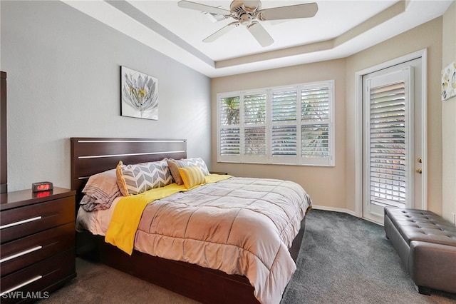 carpeted bedroom featuring access to outside, a tray ceiling, and ceiling fan