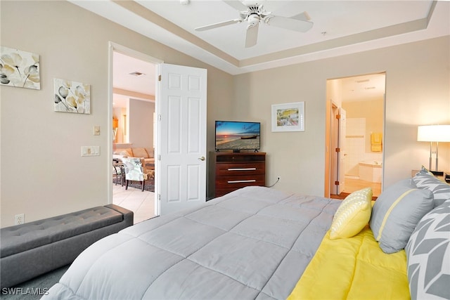 bedroom with ensuite bath, ceiling fan, and a tray ceiling