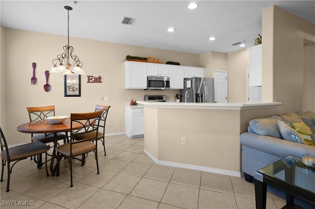 kitchen with decorative light fixtures, light tile patterned floors, visible vents, appliances with stainless steel finishes, and white cabinets