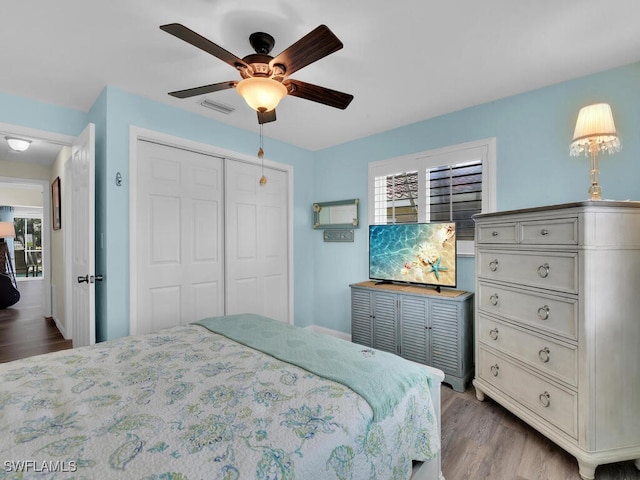 bedroom with a closet, ceiling fan, and light hardwood / wood-style flooring