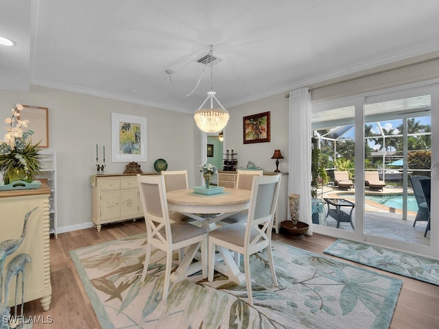 dining space with an inviting chandelier, light hardwood / wood-style flooring, and ornamental molding