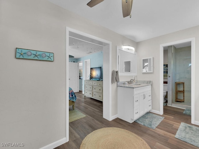 bathroom with vanity, toilet, hardwood / wood-style flooring, and ceiling fan