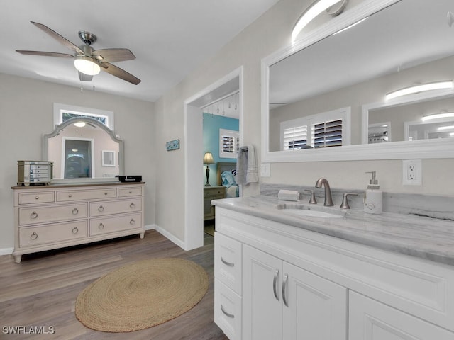 bathroom with vanity, a healthy amount of sunlight, hardwood / wood-style flooring, and ceiling fan