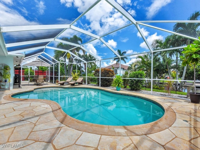 view of swimming pool with a patio area and glass enclosure