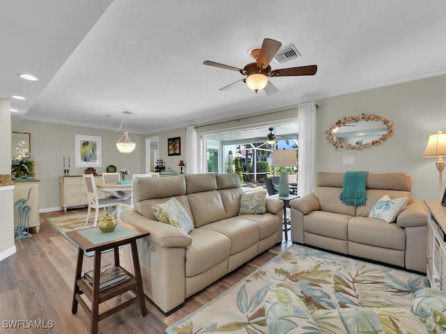 living room featuring crown molding, hardwood / wood-style flooring, and ceiling fan