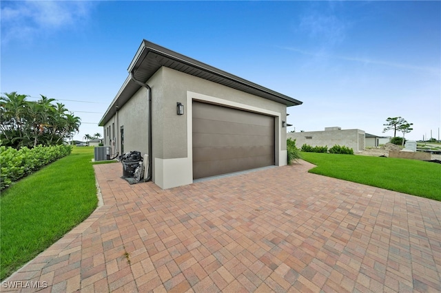 garage with a lawn and central air condition unit