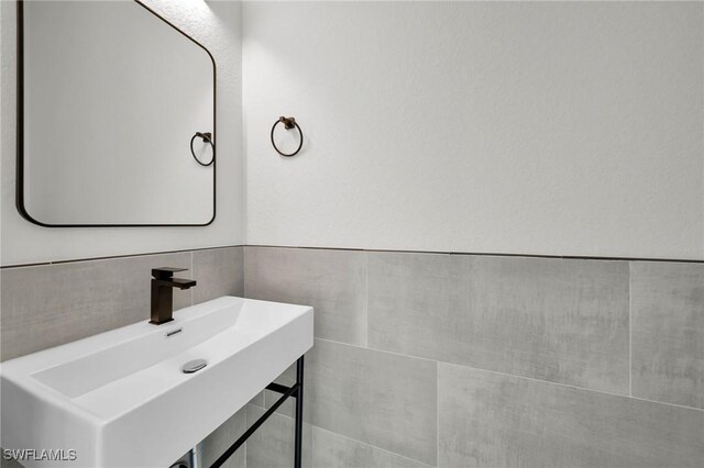 bathroom featuring tile walls and sink