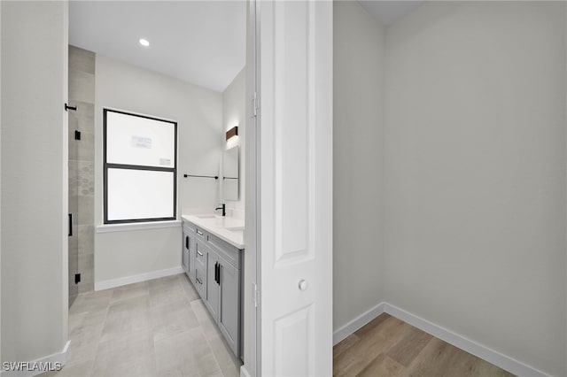 bathroom with vanity, a shower with shower door, and hardwood / wood-style floors