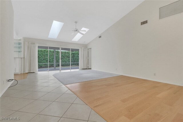 unfurnished living room with light tile patterned flooring, high vaulted ceiling, and ceiling fan