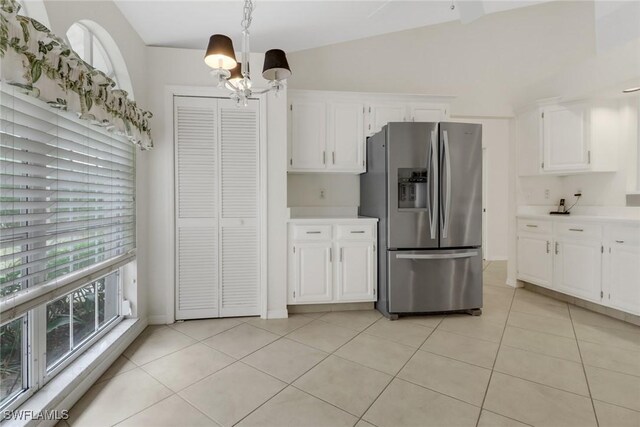 kitchen with pendant lighting, light tile patterned floors, stainless steel fridge, an inviting chandelier, and white cabinets