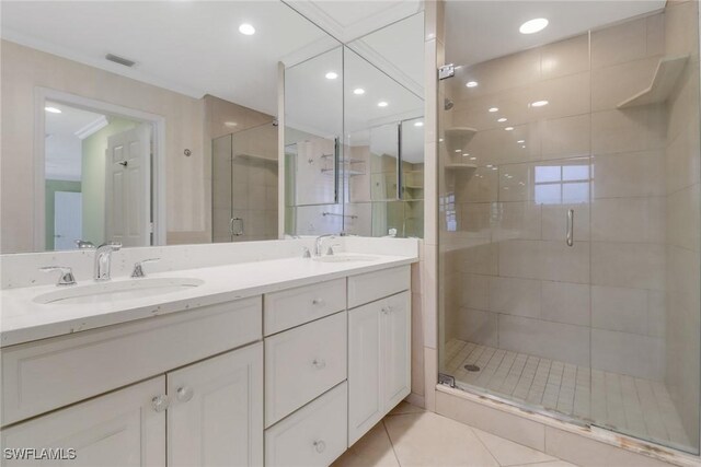 bathroom featuring tile patterned flooring, vanity, ornamental molding, and walk in shower