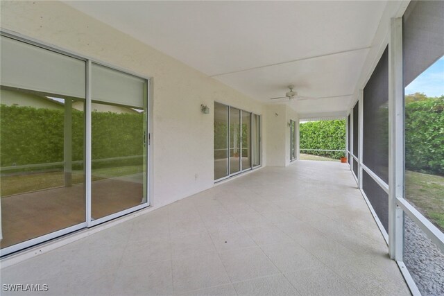 unfurnished sunroom with ceiling fan