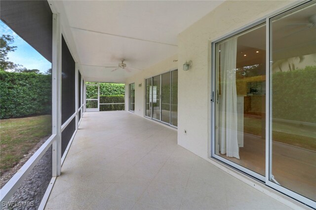 unfurnished sunroom with ceiling fan